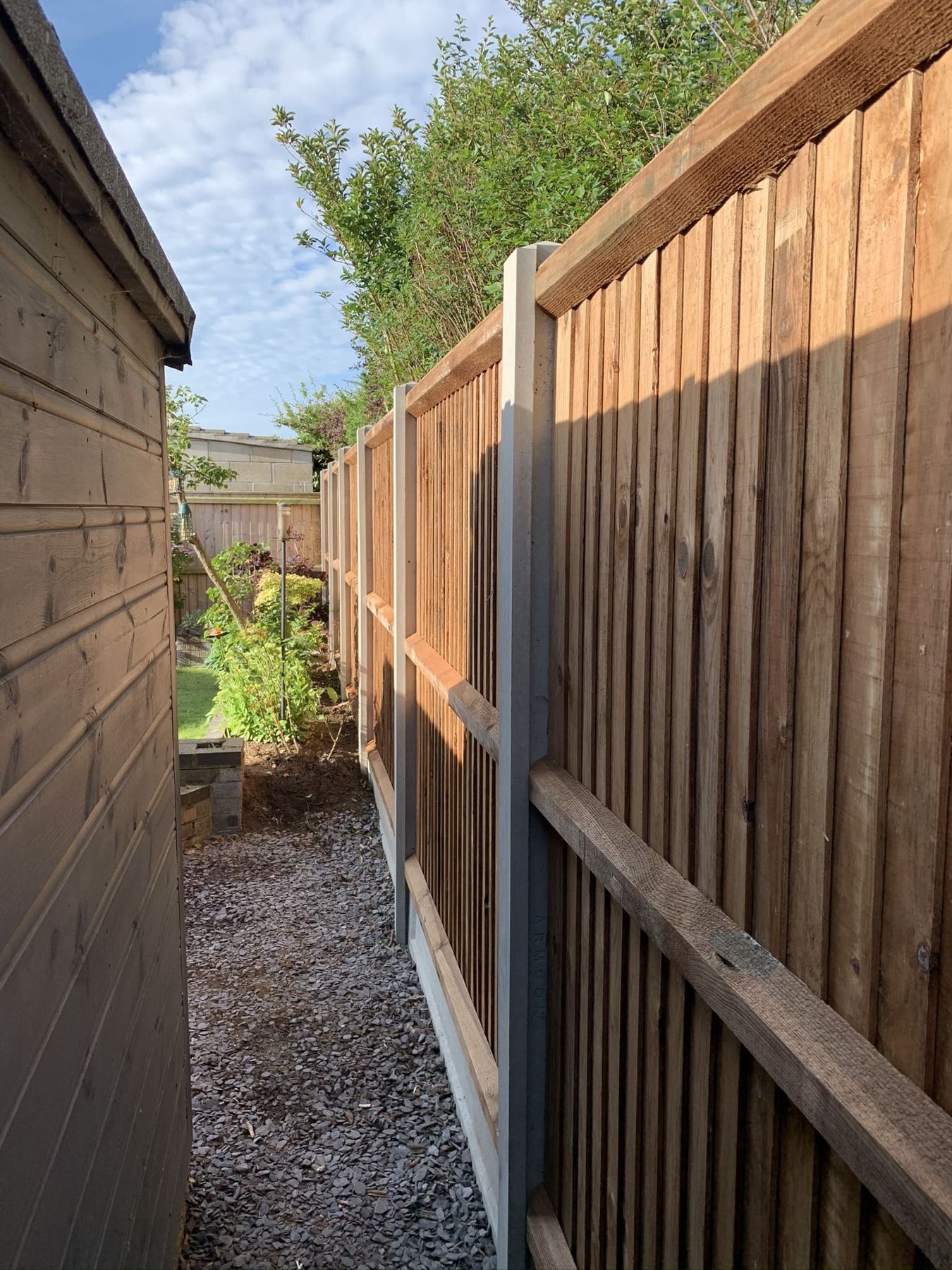 Closeboard fence on concrete posts beside a path
