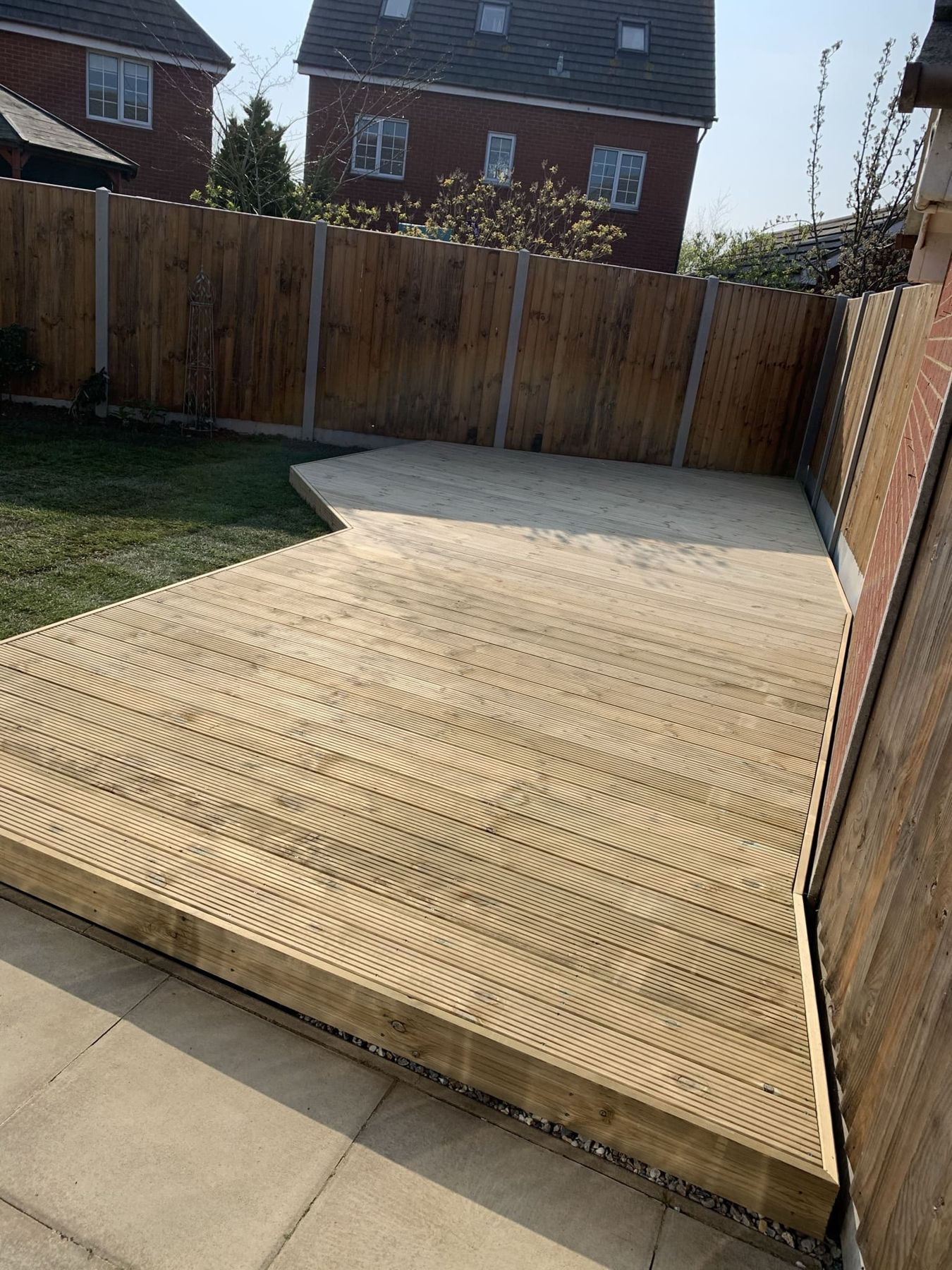 Corner timber deck against a closeboard fence