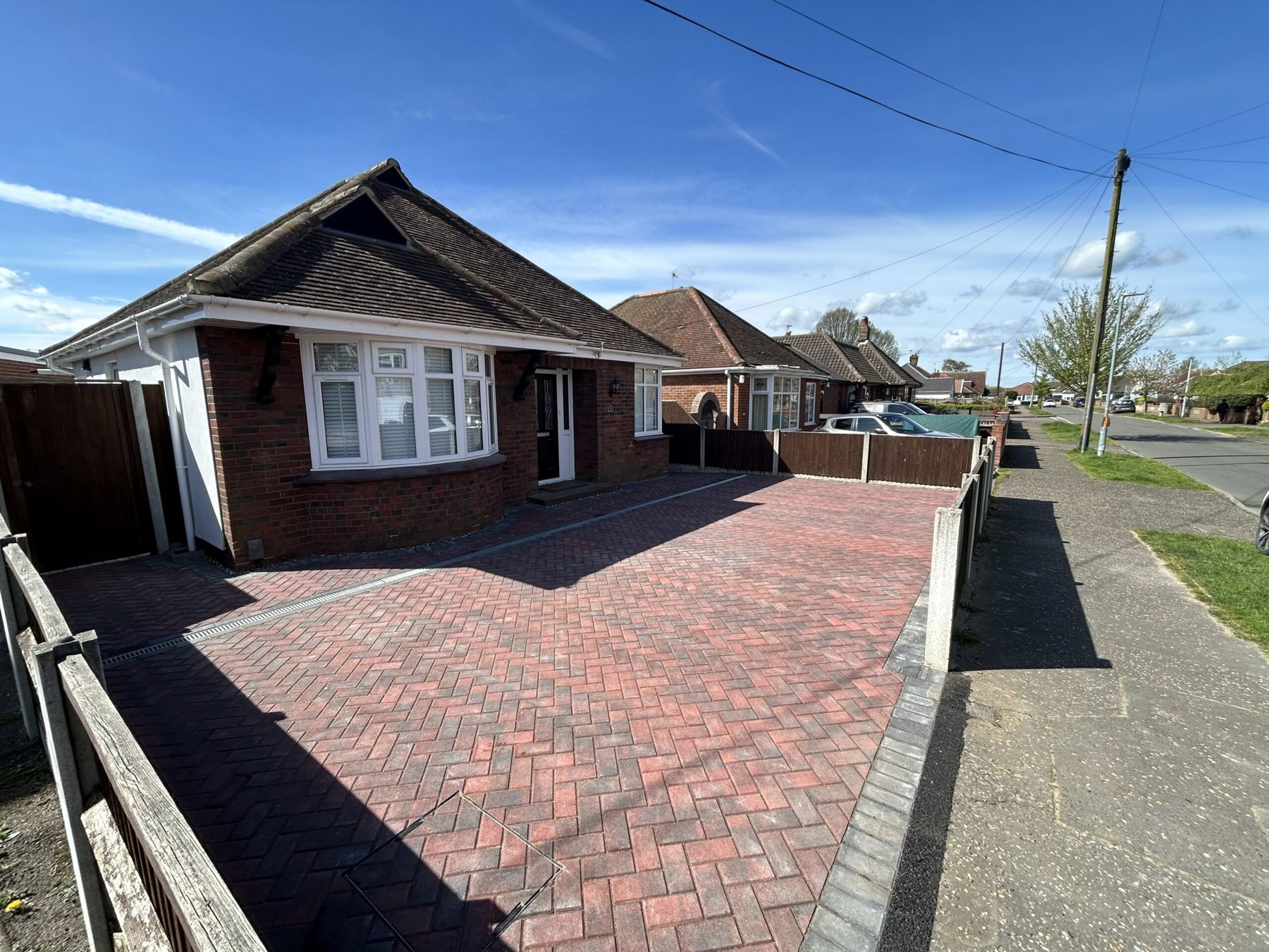 Red block paved driveway with a grey border running to the pavement