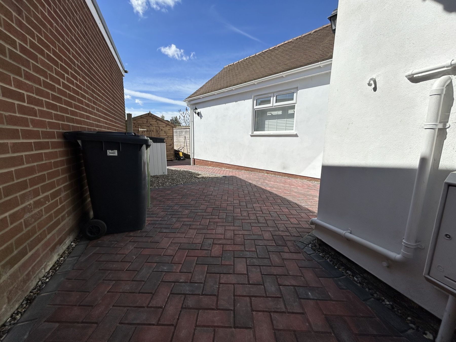 Red block paving carried down the side of a house