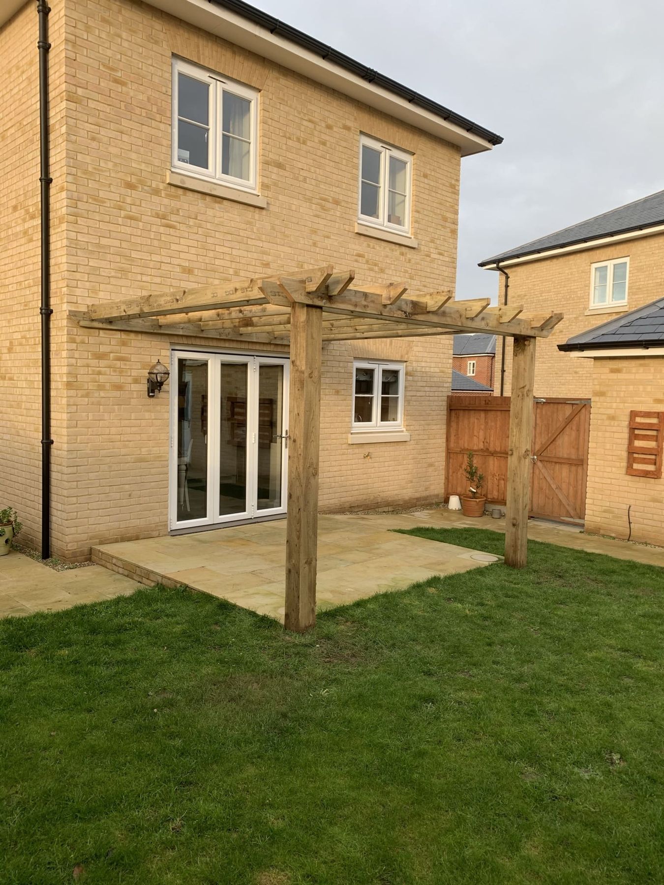 Timber pergola over a patio at a new-build house
