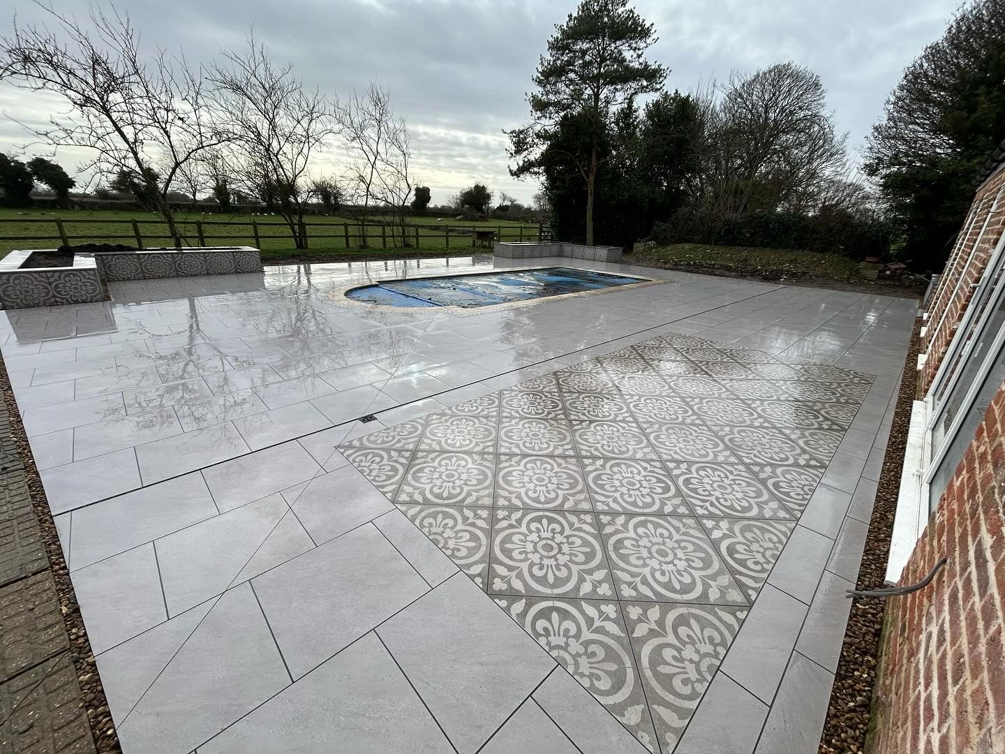Porcelain patio with a patterned inlay around an outdoor pool