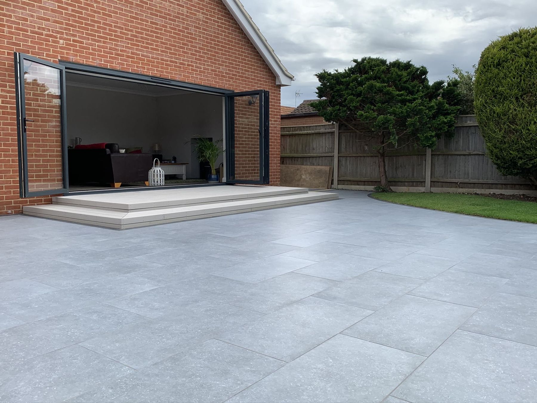 Grey porcelain patio with steps up to bifold doors