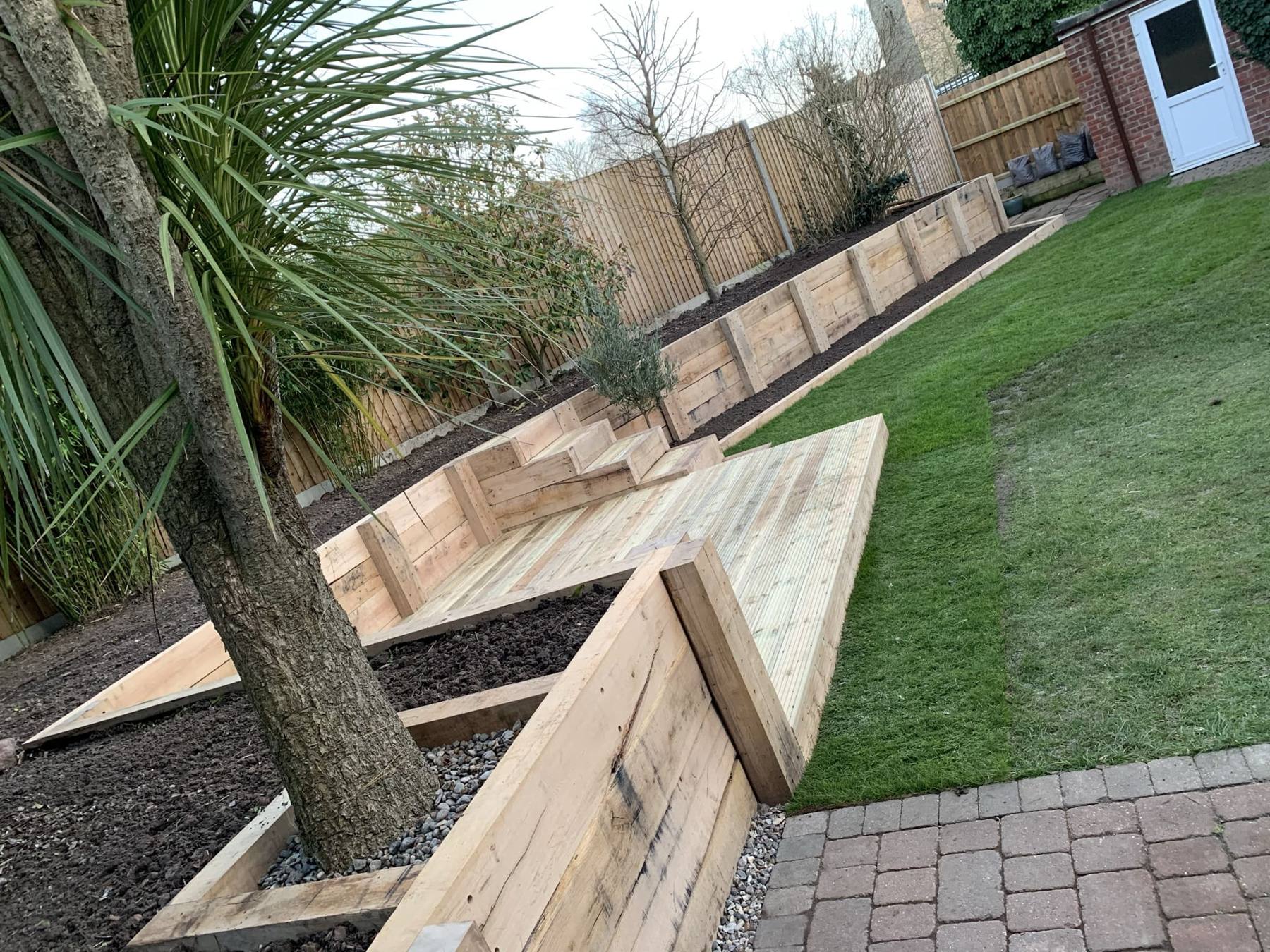 Timber sleeper retaining walls forming terraces beside a lawn