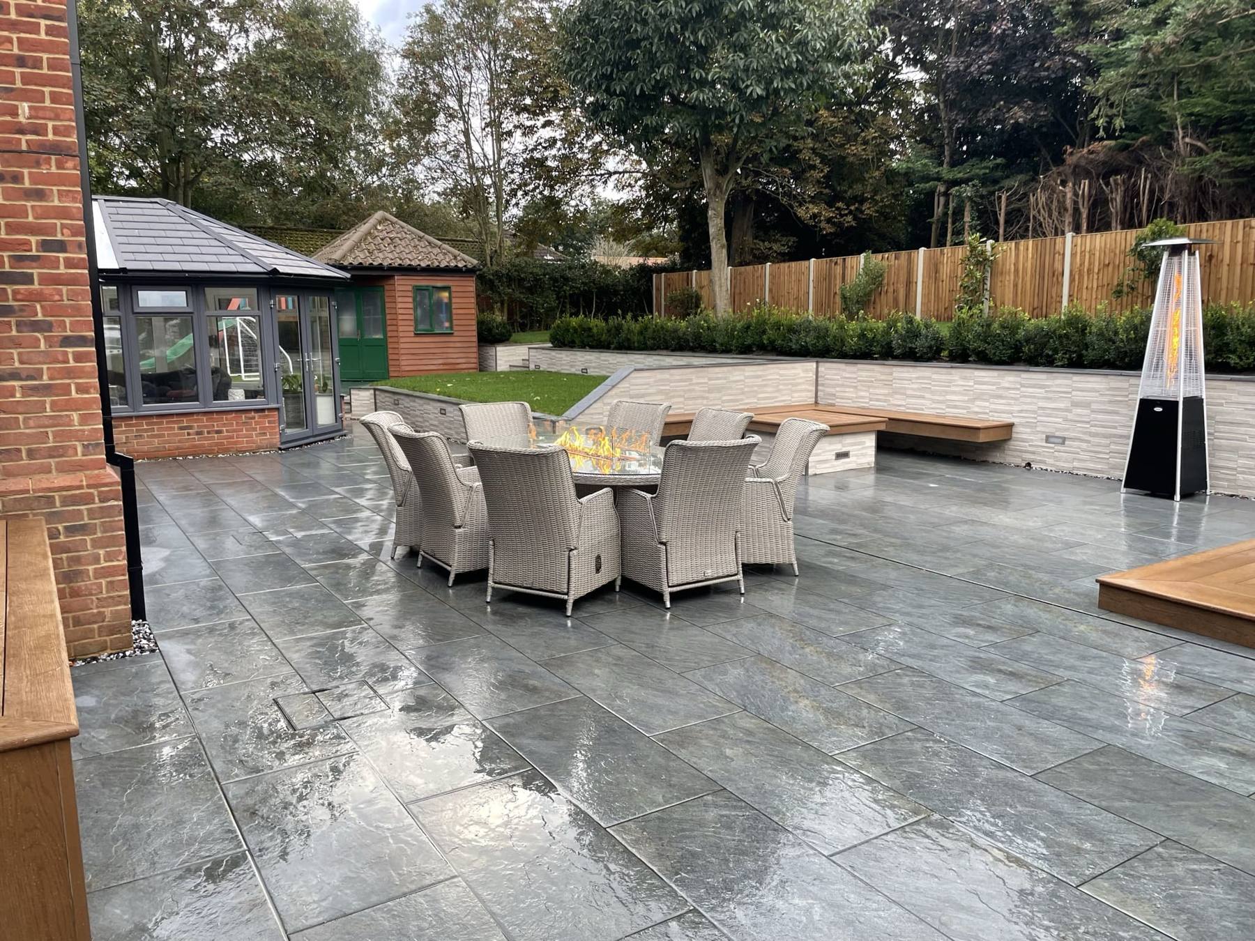 Freshly washed porcelain patio with a dining set and patio heater
